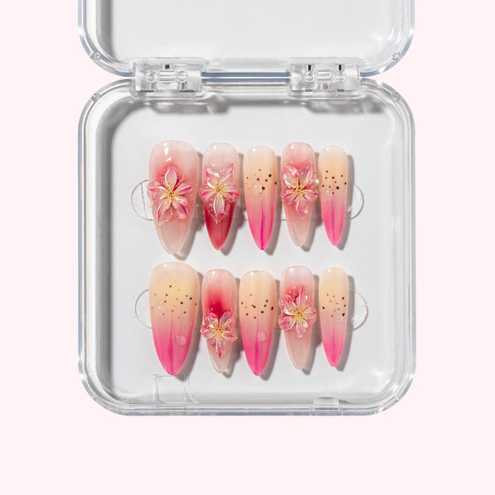 Tropical Rainforest nail set with pink gradient, black dot accents, and 3D floral petals, inspired by tropical flowers and fruits.